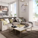 Modern open plan living room and kitchen interior with L-shaped sofa and floor-to-ceiling glass doors at Urbana I in Emaar South Dubai