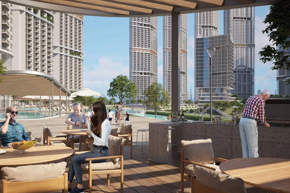 Residents enjoying outdoor dining and BBQ area with views of luxury towers at 350 Riverside Crescent in Sobha Hartland II, Dubai