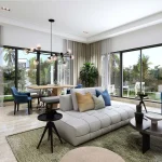Modern open plan living room and dining area with floor-to-ceiling glass windows overlooking garden at DAMAC Riverside Lush Dubai