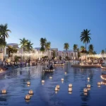 Illuminated evening view of water lagoon, floating lanterns, and community gathering spaces at DAMAC Riverside Lush Dubai