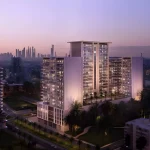 Aerial view of Binghatti Amberhall residential building in JVC Dubai illuminated at sunset with city skyline in background