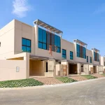 Street view of modern townhouses row with glass facades and covered driveways at Grand Views in Meydan Dubai