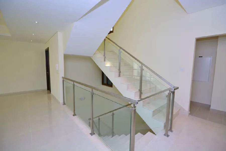 Marble internal staircase featuring stainless steel and glass railings inside Grand Views townhouse at Meydan Dubai