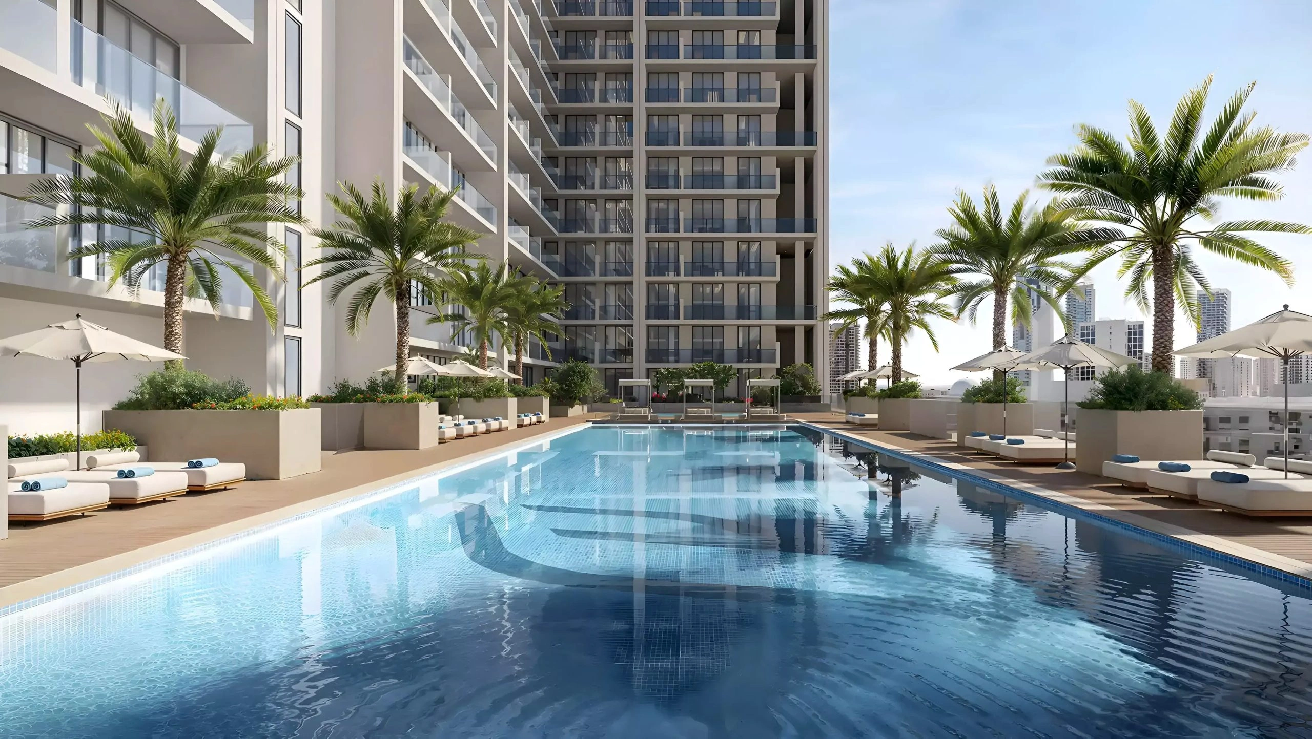 Outdoor swimming pool with sun loungers and palm trees at Binghatti Amberhall in Jumeirah Village Circle, Dubai