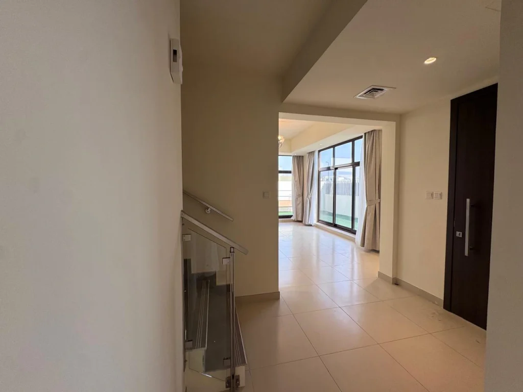Modern interior entrance hallway featuring glass staircase and living space in a 4 bedroom townhouse at Senses at The Fields Meydan