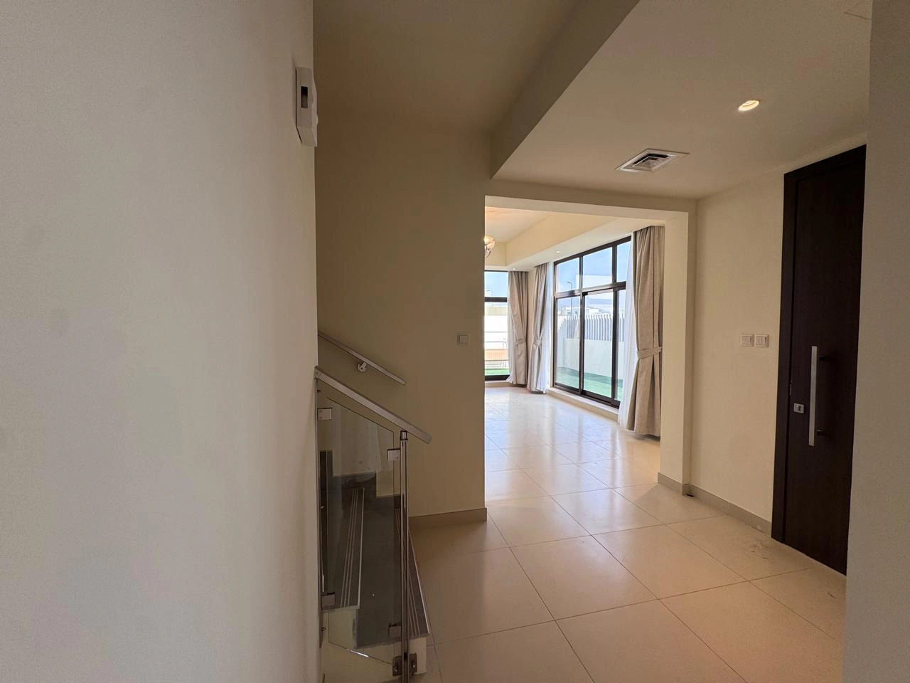 Modern interior entrance hallway featuring glass staircase and living space in a 4 bedroom townhouse at Senses at The Fields Meydan